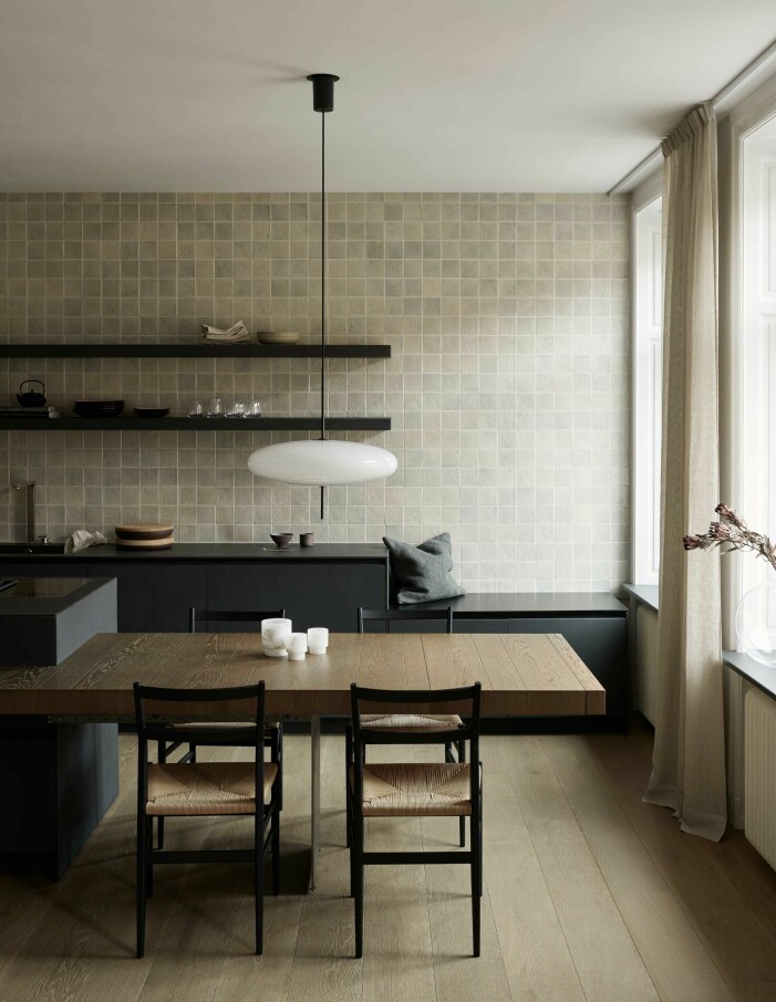 Det strama köket från italienska Modulnova mjukades upp med en fondvägg i handgjort kakel.Stolar Leggera chair från Cassina och taklampa Model 2065 från Astep. Kudde och gardiner uppsydda i textilier från Astrid. Kök i mjuka färger och modern inredning.