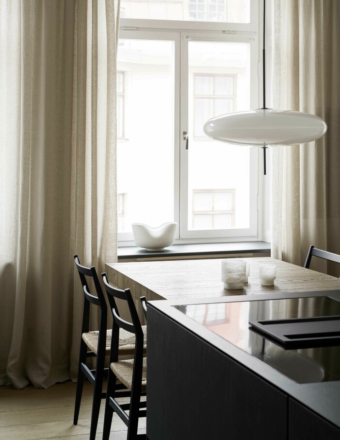 Få utvalda detaljer ger inredningen ett stillsamt lugn. Stolar Leggera från Cassina, taklampa Model 2065 från Astep och ljuslyktor av Michel Verheyden/Bert van Hoecke Interiors. Matplats inne i kök.
