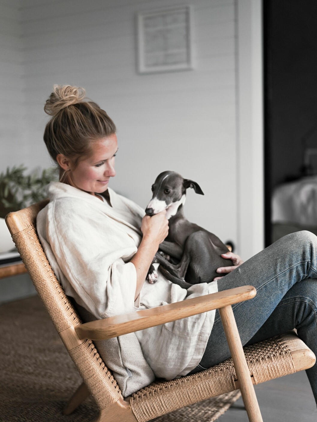 Pella i Hans J Wegners fåtölj CH25 med italienska vinthunden Gypsy. Stylisten Pella med hunden Gypsy.