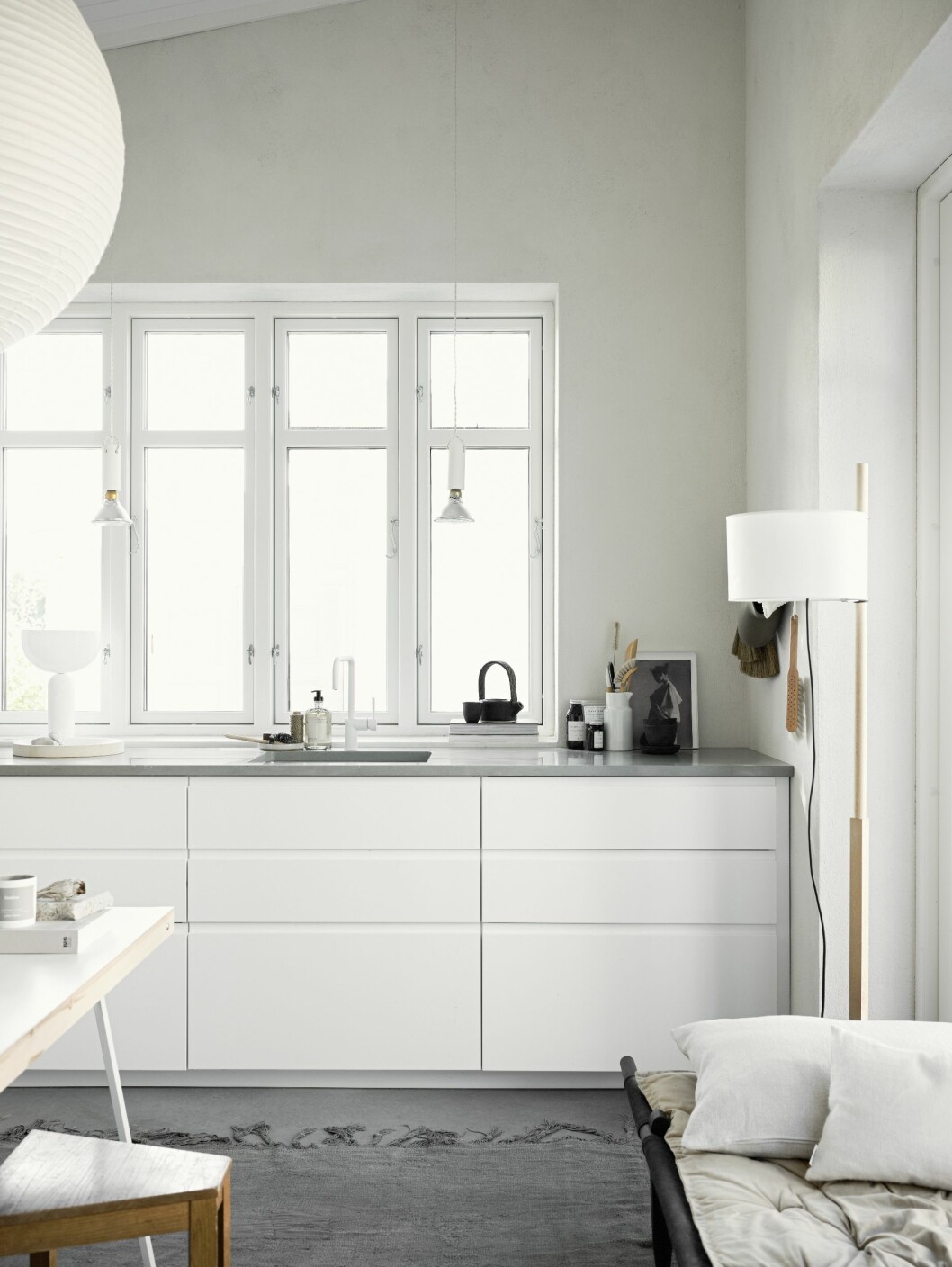 Kortsidan med full takhöjd har inretts med kök från Ikea. Bänkskiva, Silestone Cygnus. Vit blandare från Nivito. Vintage matta, Private 0204. Dagbädd Safari från Skovshoved. Golvlampa TMM från Santa & Cole. Kök från IKEA med bänkskiva från Silestone Cygnus.