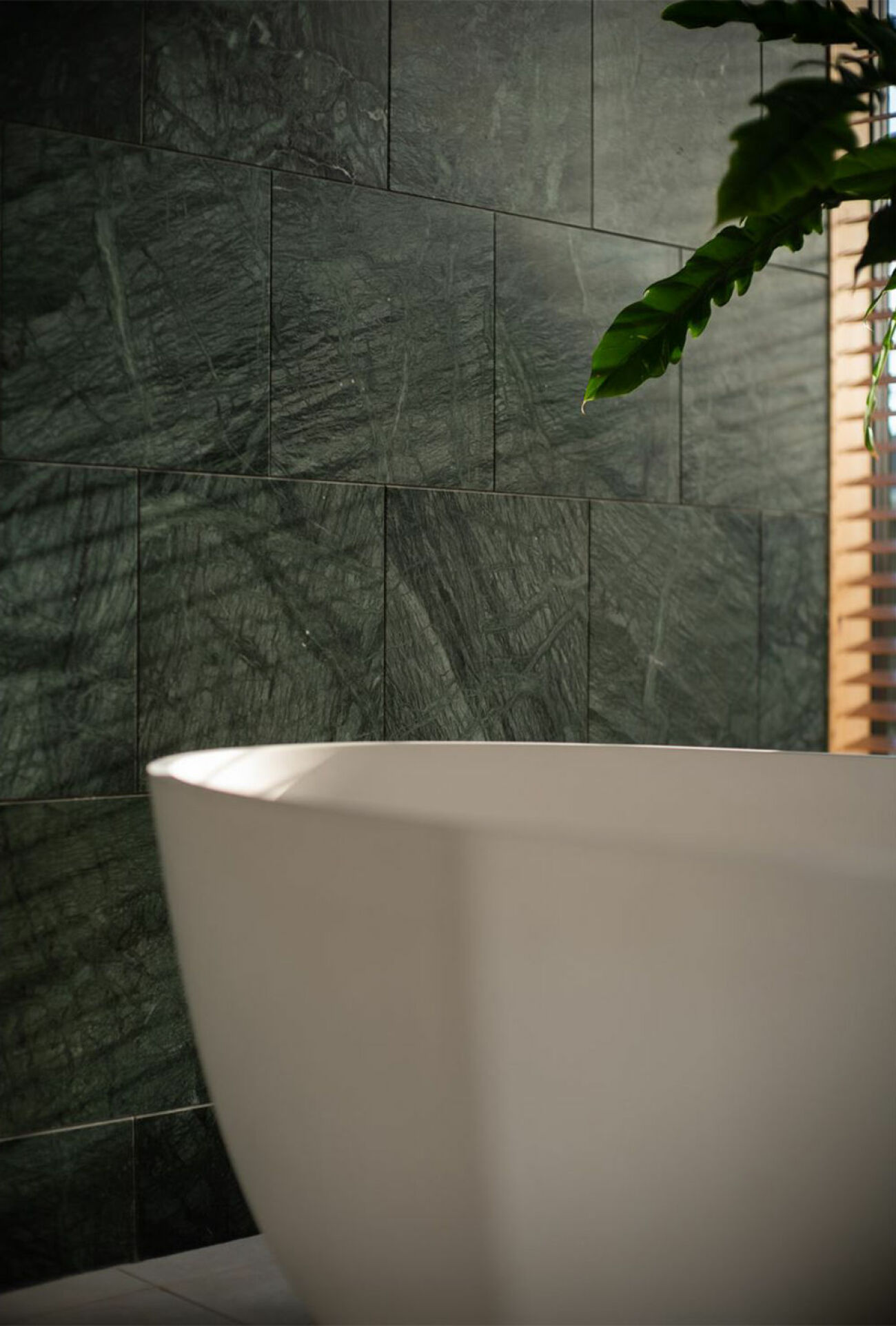 Lyxigt badrum med vägg i grön marmor