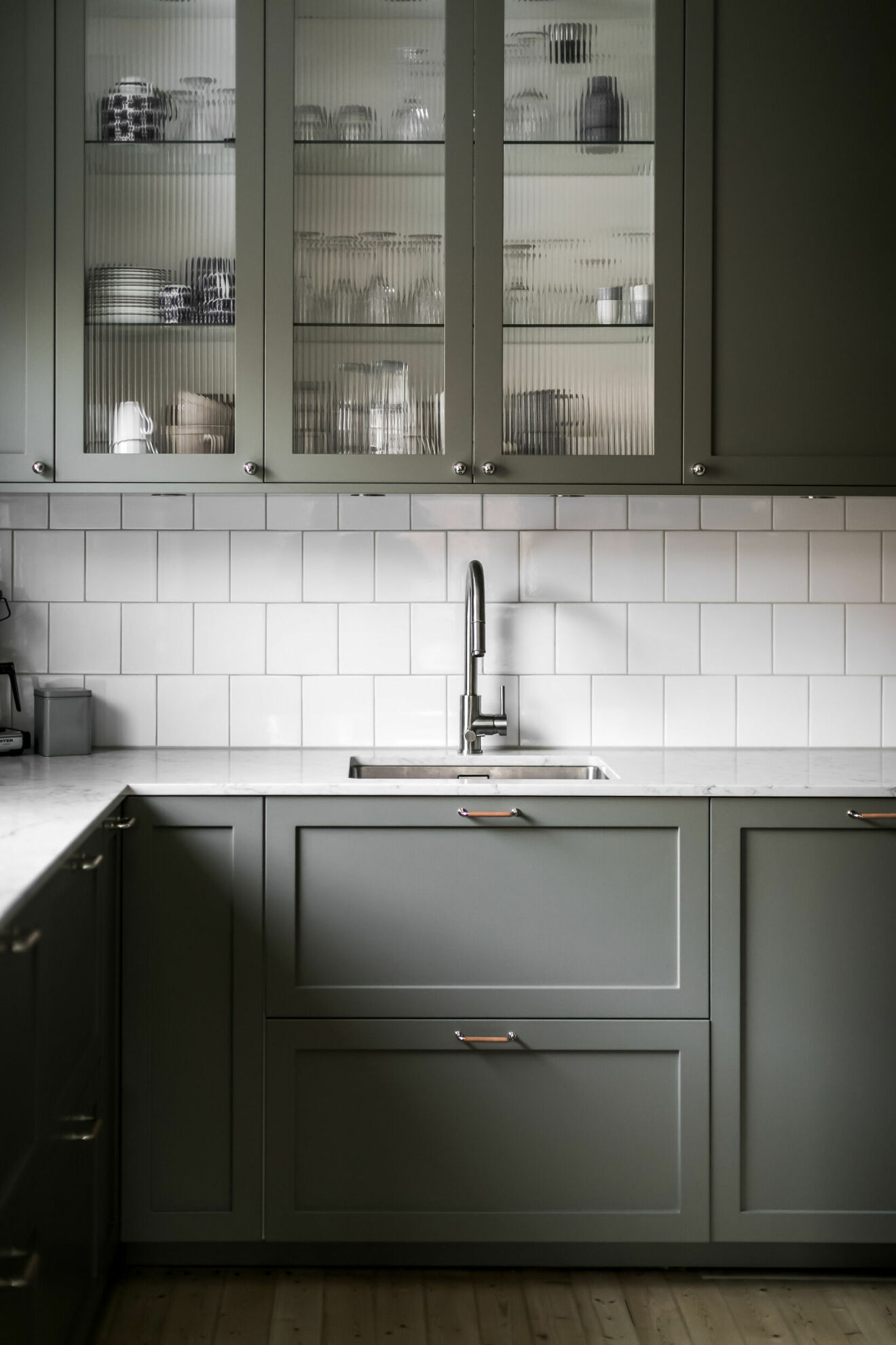 kök i varmgrå färg med vitrinskåp