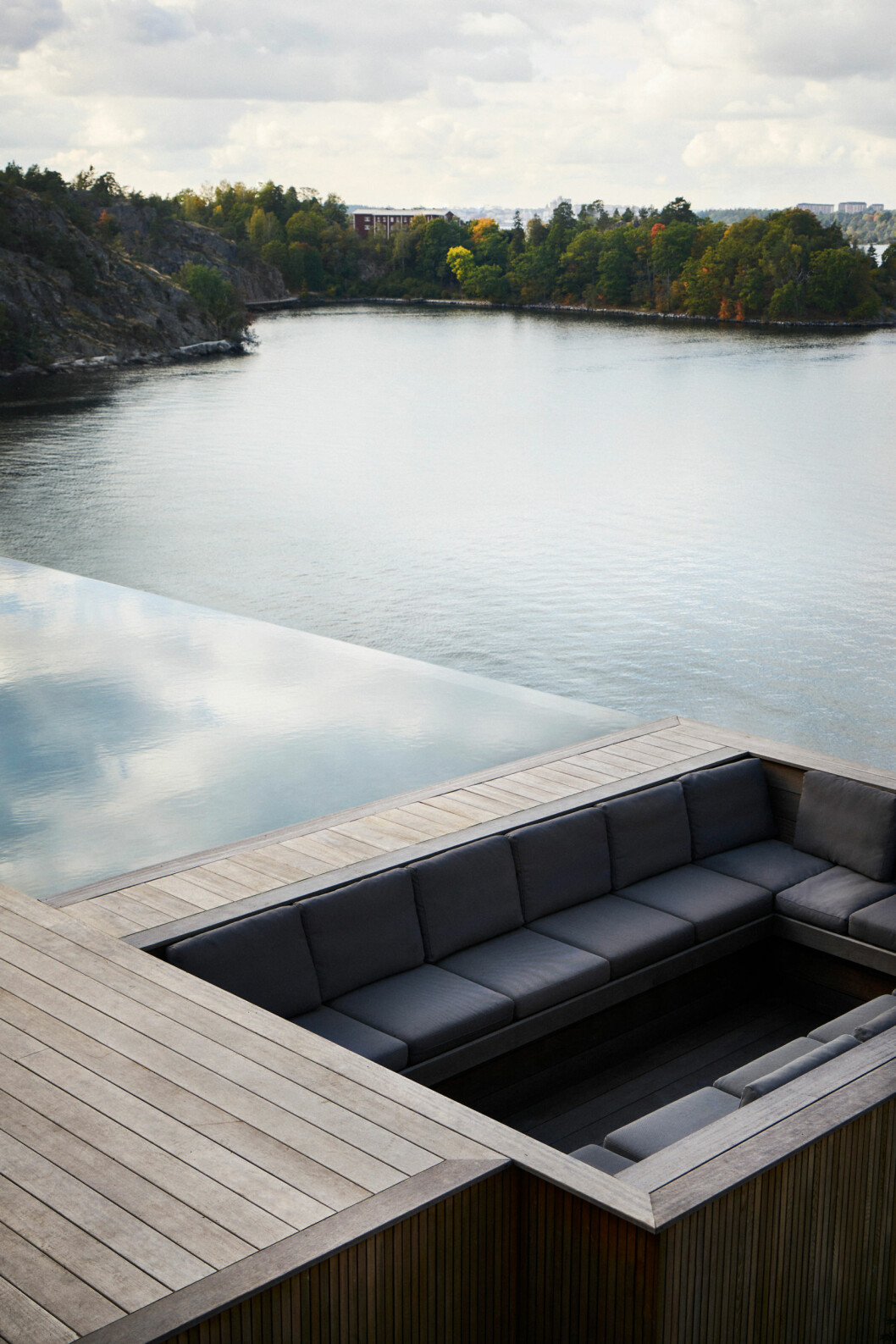Infinitypool på Gotland av Mondial pool Sweden. Nedsänkt sitthörna med skydd för vind och väder. Foto: Emma Jönsson Dysell Inspirerande infinitypool med medsänkt sitthörna.