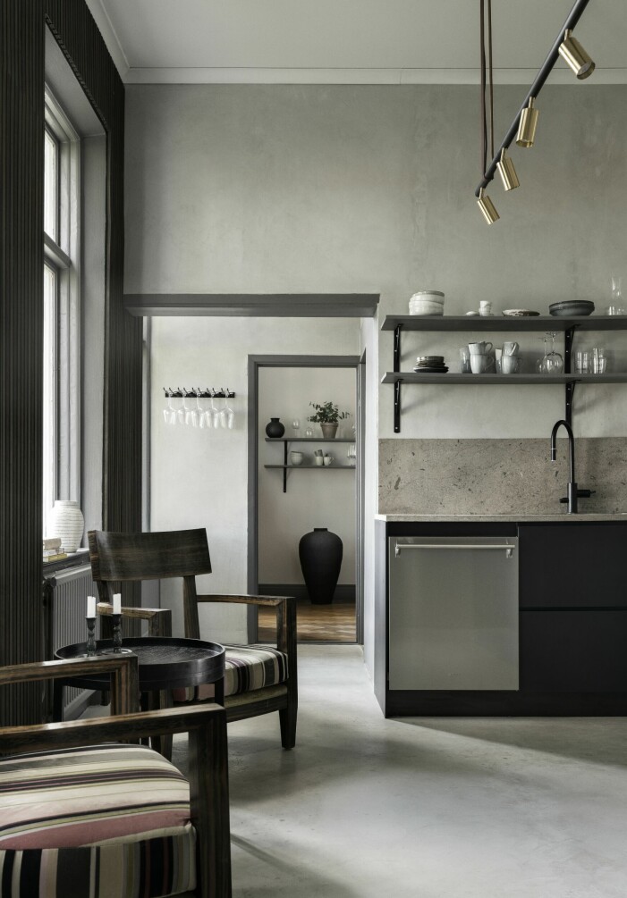 I köket dominerar gotländska material. Golvet är tillverkat av mikrocement från gotländska Design by cement och stänkskydd och bänkskiva är i gotländsk kalksten från Stenfabriken i Burgsvik. Den svarta urnan kommer från Muubs och står i ett mellanrum som fungerar som genomfart till matsalen. Här står även vinkylen. Kök i mycket modern tappning.