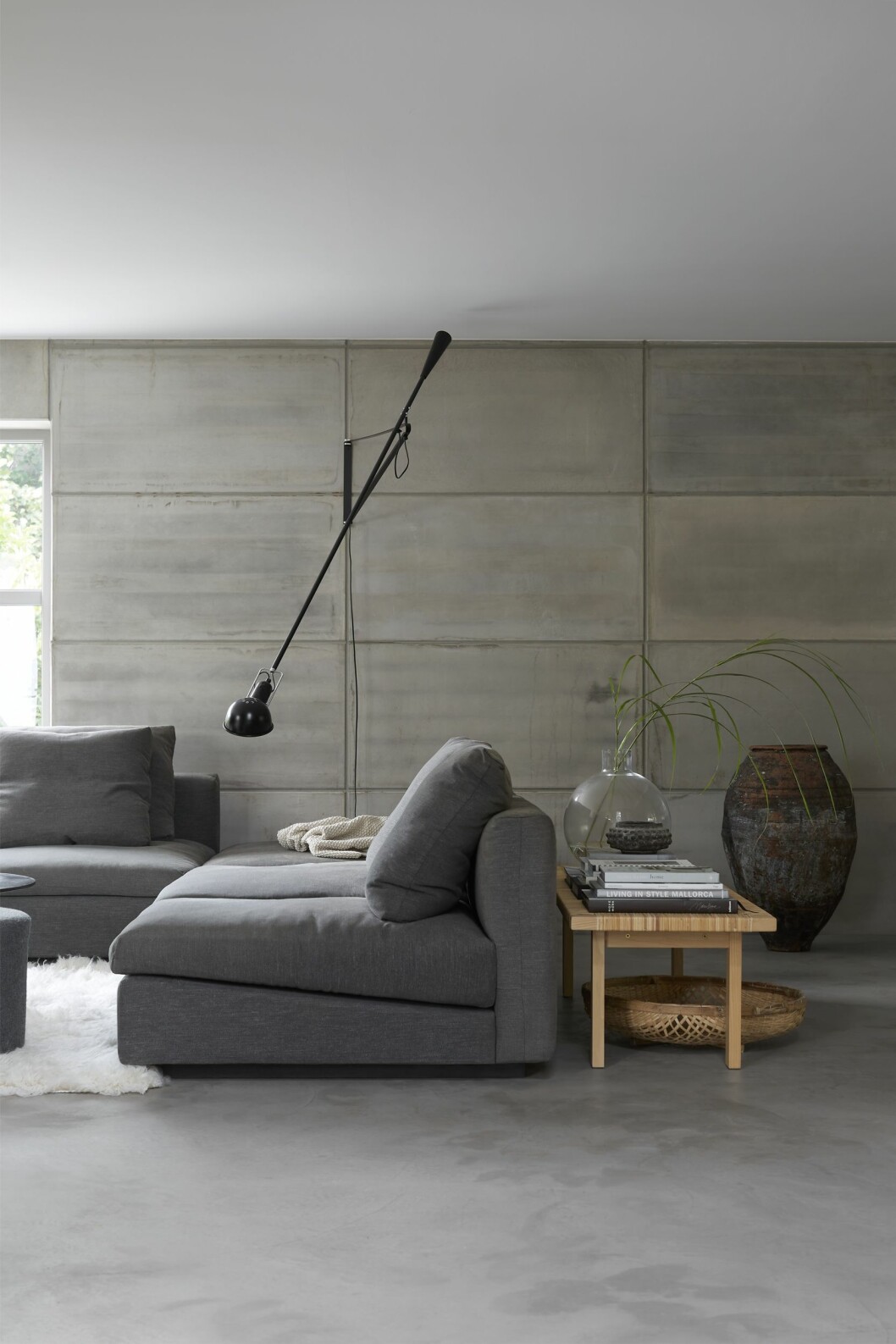 Vardagsrum mot trädgården. Soffa från Eilersen. Lampan Flos 365. Bänk från Ikea. Stor terrakottakruka från Apotekarns och vas Pallo av Carina Seth Andersson för Skrufs glasbruk. Vardagsrummet i arkitektritade huset.