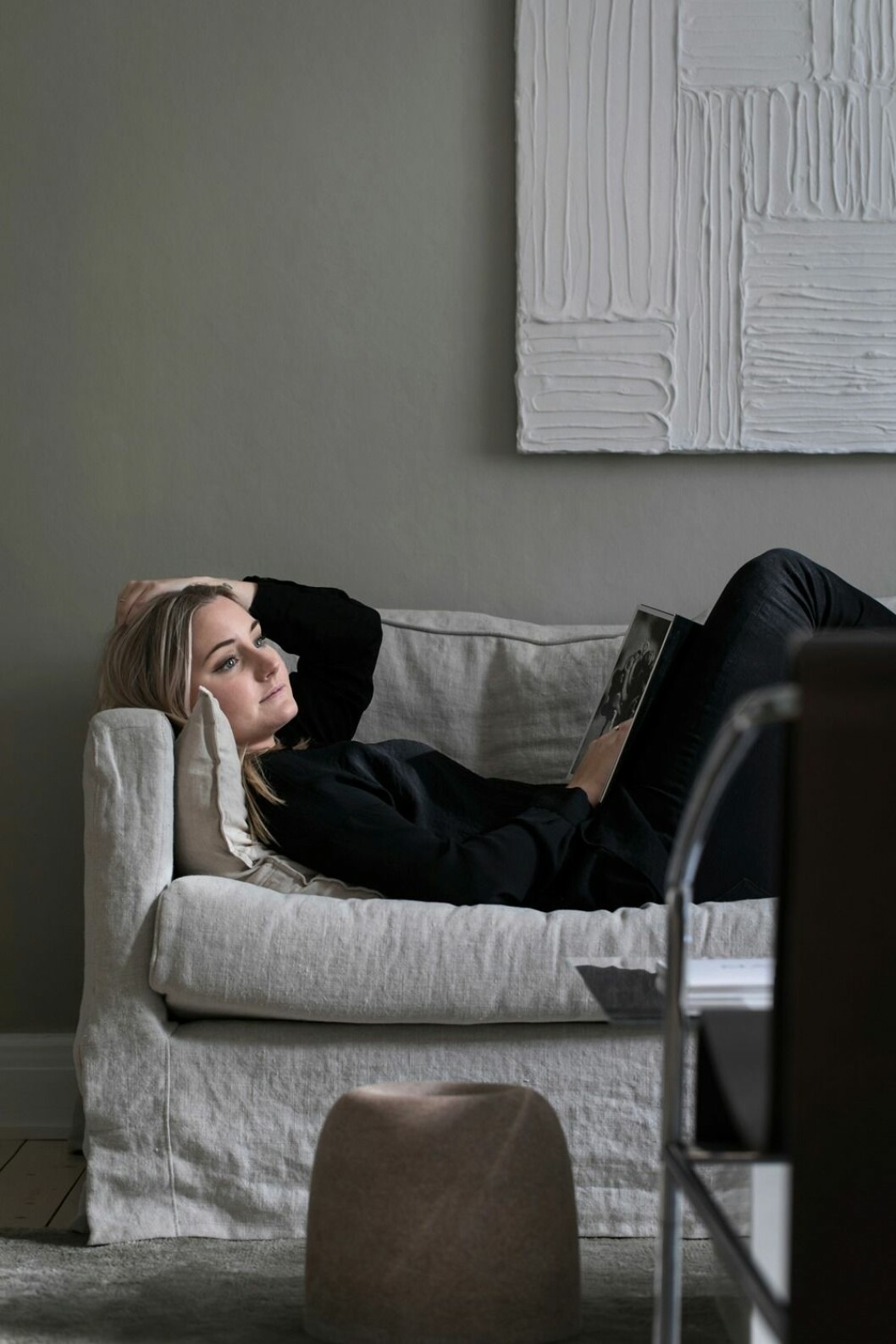 Elin njuter av lugnet hemma. Tavlan över soffan har konstnären Anette Hallbäck gjort. Skulpturen på golvet är av Fredrik Persson.