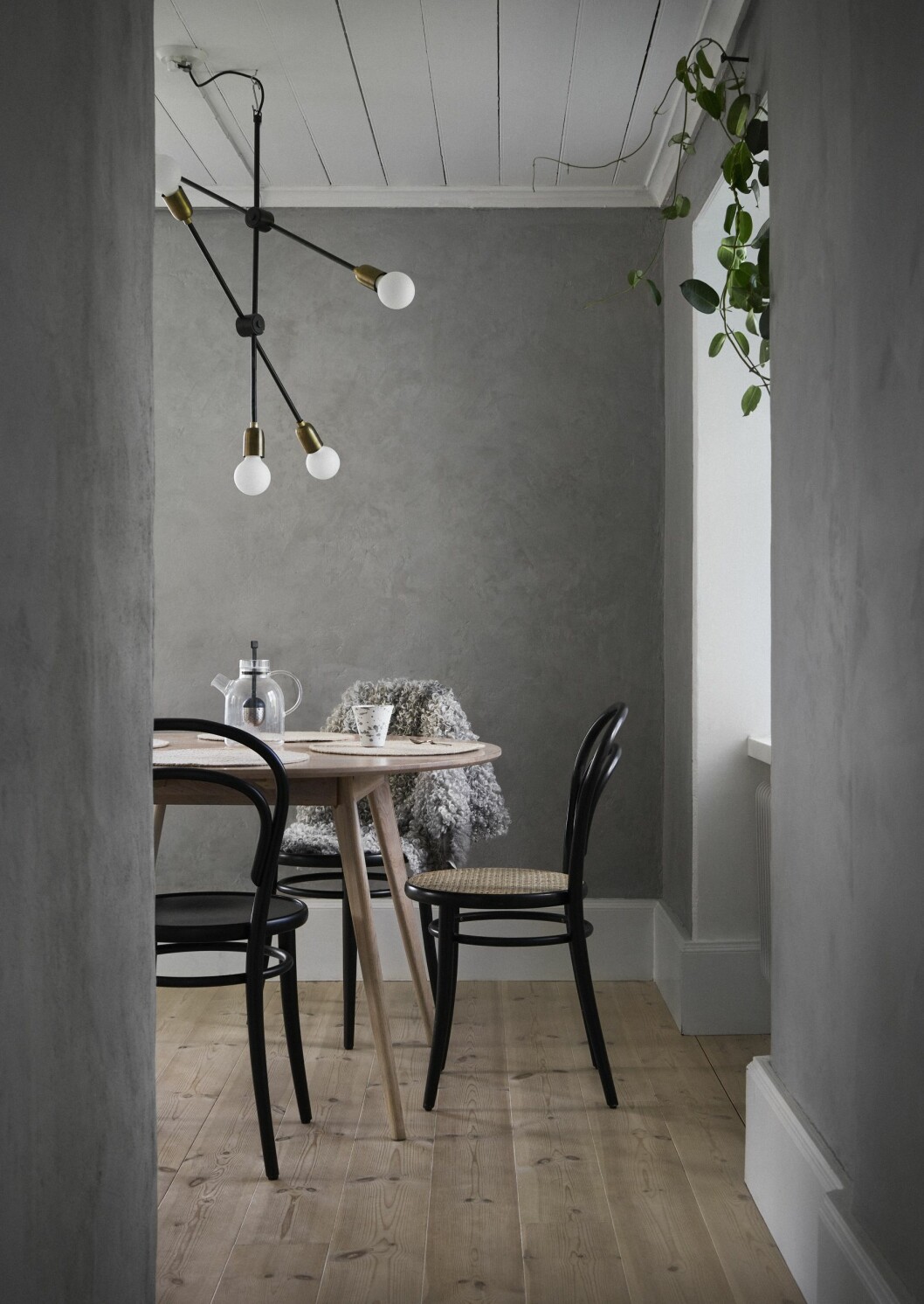 Ljuset fångas upp i stenväggarna i köket, som har fem fönster i olika väderstreck. Stolar från Thonet. Gotlandslammskinn från en gård i Ala. Lampa från House Doctor. Kök med grå väggkulör.