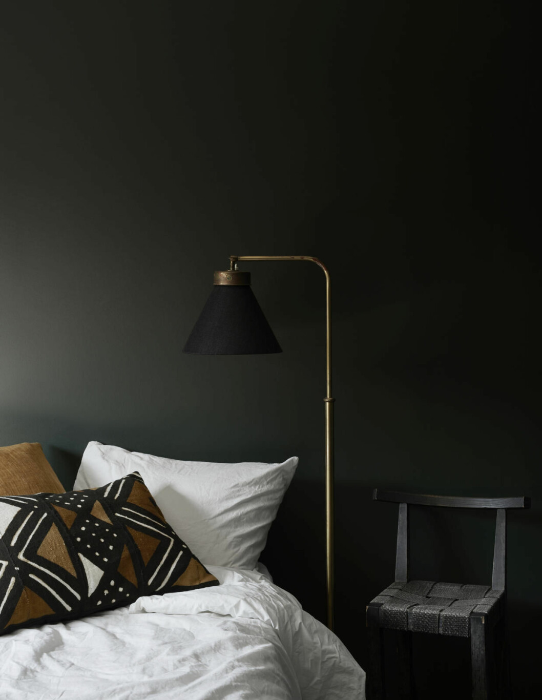 Golvlampa Svenskt Tenn, orange kudde Svenskt tenn, mönstrad kudde Colors of Africa. Stolen har Simone fått av sin mamma och är gjord av Björn Sikehag som även gjorde mycket av inredningen till Simones föräldrars ställe på Nybrogatan – Molvidson Coffee & Shop.