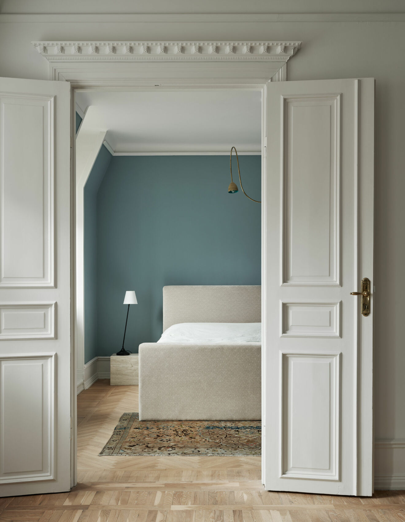 Sovrum i snarlik gustaviansk blå med en liten twist. Sängbordet av Sofia Ristic design för Studio Vraco. Säng, Jotex. Matta, vintage. Taklampa, Svenska armaturer.