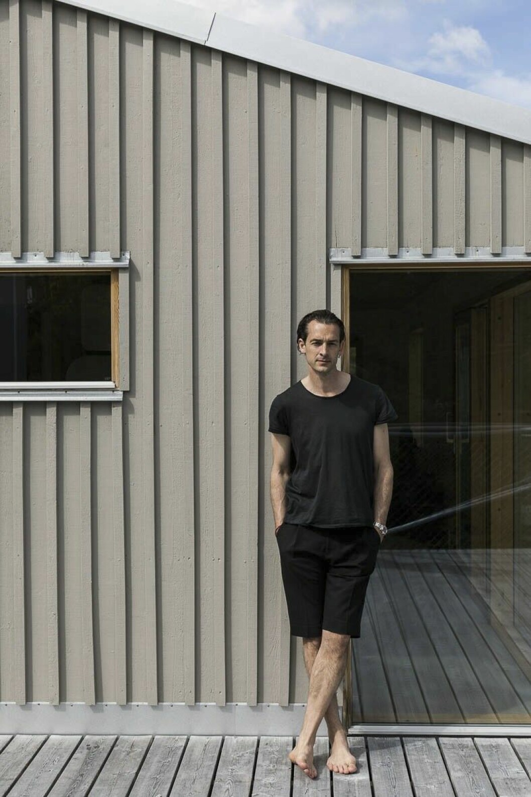 Arkitekten Leo Beccari vid sitt ombyggnadsprojekt. Det fanns redan träpanel på vissa delar av det ursprungliga huset. Vid ombyggnaden spann man vidare på det och lät målad träpanel täcka hela huset. Färgen är grå med ett litet gult stick i.