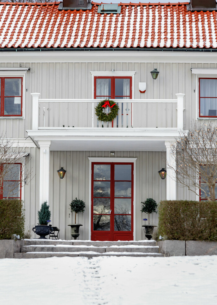 Röda detaljer går fint ihop med både grått, grönt och vitt. Foto: TT/Marie Linnér/Scandinav hus med röda fönsterkarmar och en röd dörr