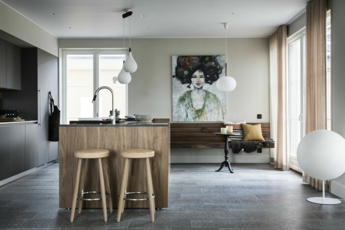 Kök från Planoform, Binova med en köksö, och barstolarna<span class=" italic" data-lab-italic_desktop="italic"> CH58</span> av Hans J Wegner. Kranar från Dornbracht och taklampor från Domino antik. Tavla av Marina Blomdahl. Platsbyggd kökssoffa, Nacka Snickerier. Golvlampa, <span class=" italic" data-lab-italic_desktop="italic">Moon</span> av Davide Groppi, Kök med detaljer i trä