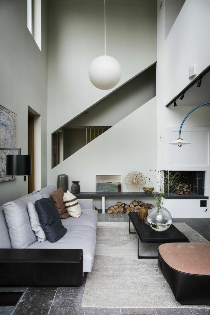 Konst på väggen: <span class=" italic" data-lab-italic_desktop="italic">Varginnan</span> av Rebecka Bebben Andersson. Soffa med tillhörande sittpuff, Knoll. Soffbord, Ethnicraft/Posh living. Glasvas<span class=" italic" data-lab-italic_desktop="italic"> Pallo</span>, Carina Seth Andersson för Skruf. Matta, Layered. Taklampa i rispapper, <span class=" italic" data-lab-italic_desktop="italic">Moon F</span> av Davide Groppi. På bänken vid spisen, vaser från Posh living. Konstfoto <span class=" italic" data-lab-italic_desktop="italic">Ear to the ground </span>av Ulrika Sparre. Klocka från Karlsson. Skandinaviskt vardagsrum