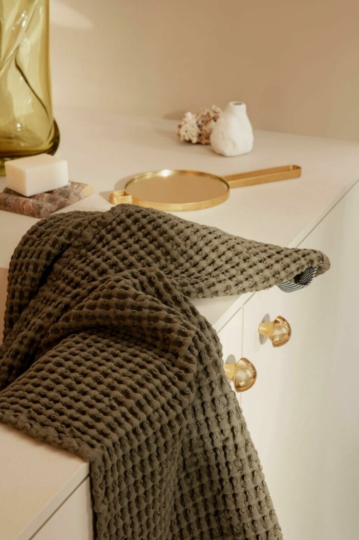 Börja småskaligt och känn efter vilka murriga kulörer som känns bäst tack vare badrumstextilier. Foto: Ferm Living. Så skapar du ett tidlöst och jordnära badrum, grön handduk