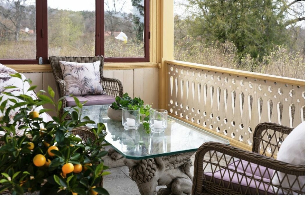Veranda med kalkstensgolv och möbelgrupp i rotting. Veranda med möbelgrupp.
