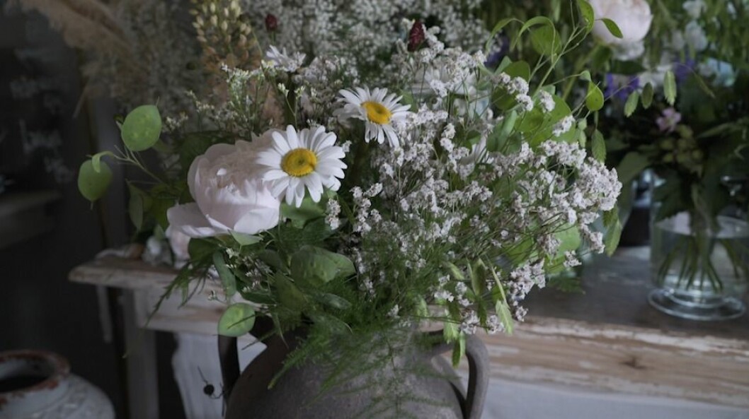 Den färdiga blombuketten i en rustik vas. Så vacker och somrig. Blombukett i rustik vas.