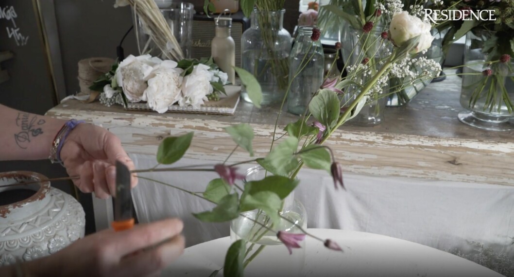 Floristen visar hur hon snittar sina blommor till blombuketten och berättar varför det är viktigt med en lång snittyta. Snitta blommor.