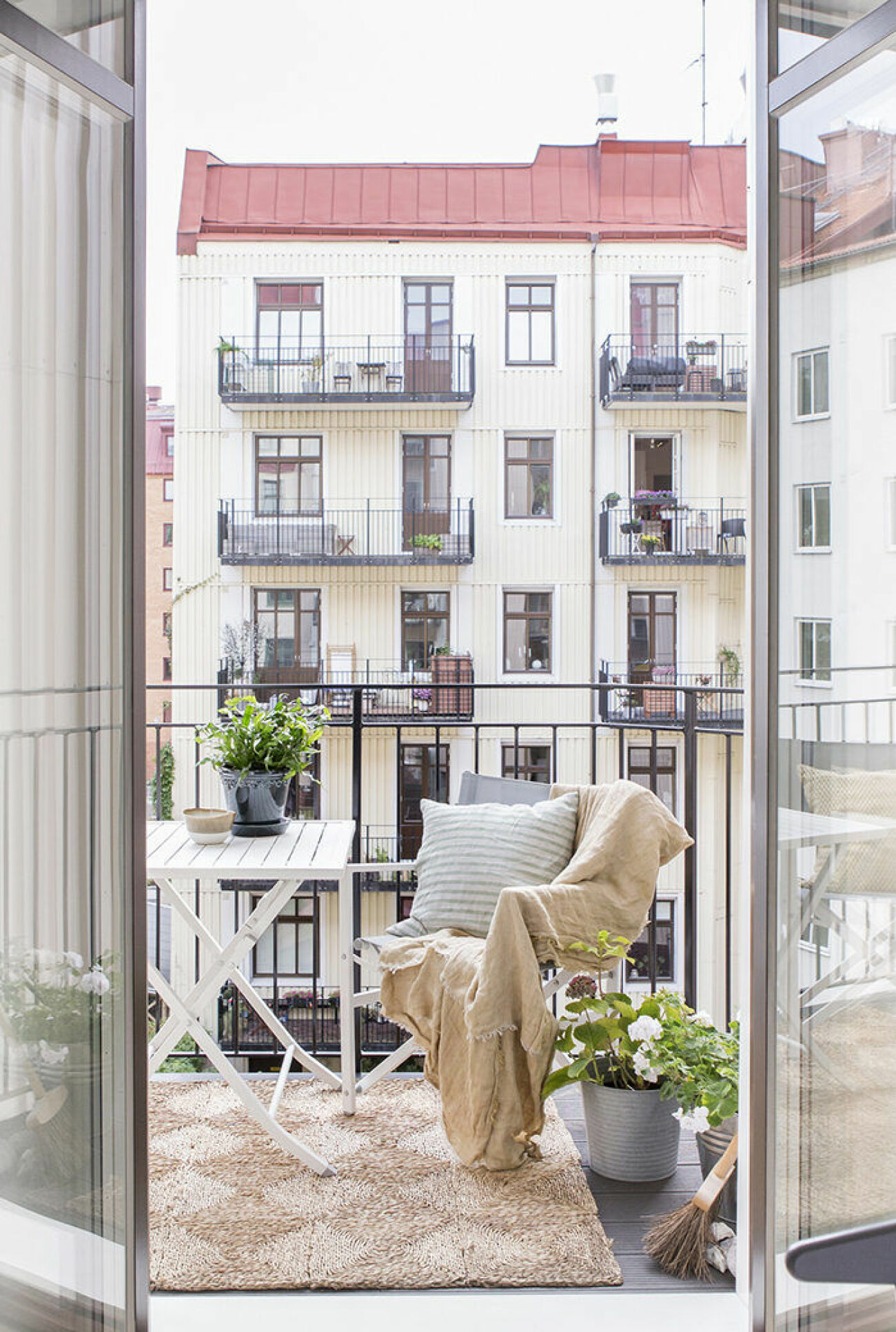 Skandinaviskt inredd balkong med naturnära färger och matta på balkongen