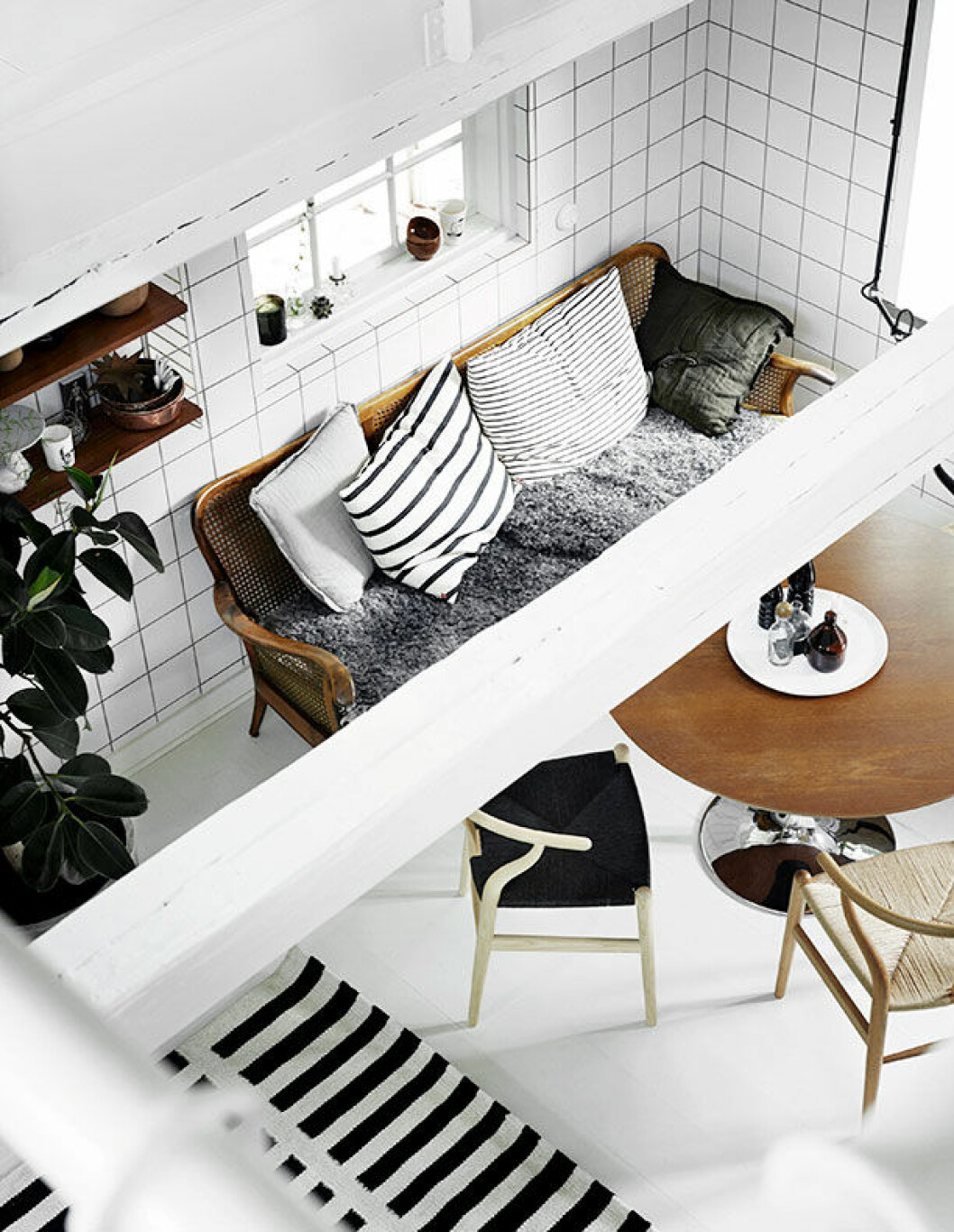 <em>Soffan är köpt på Bukowskis, kuddarna är från Posh Living. Bordet i valnöt är specialgjort på beställning. Fårskinnen är alla köpta från granngården. Y-stolarna och den svartvita ullmattan kommer från Olsson & Gerthel. På loftet ovan köket har barnen Uma och Lou sina rum. De har varsin »flygel« på ovanvåningen med eget badrum.</em> sofia odier monokromt skane 12