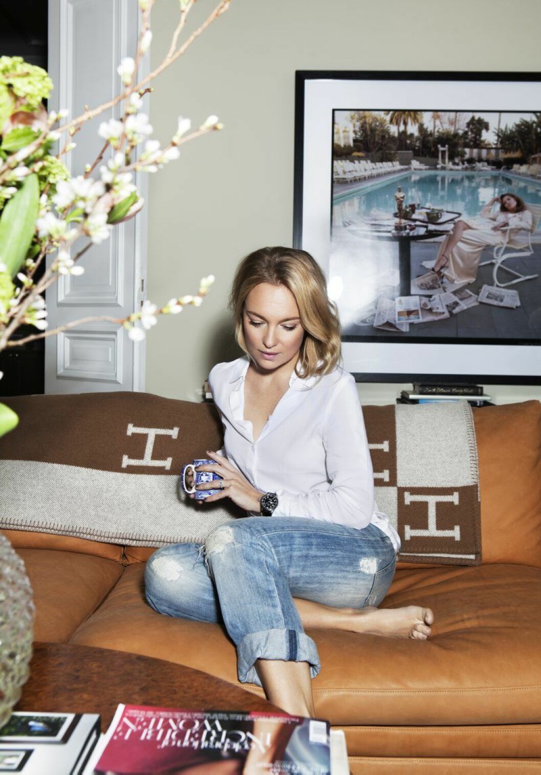 Sofia, klädd i skjorta från Dagmars bassortiment, sitter framför fotokonst av Terry O’Neill, som Sofia och hennes man träffade i samband med att de köpte tavlan på photogallery.se. Sofia Wallenstam_hemma hos