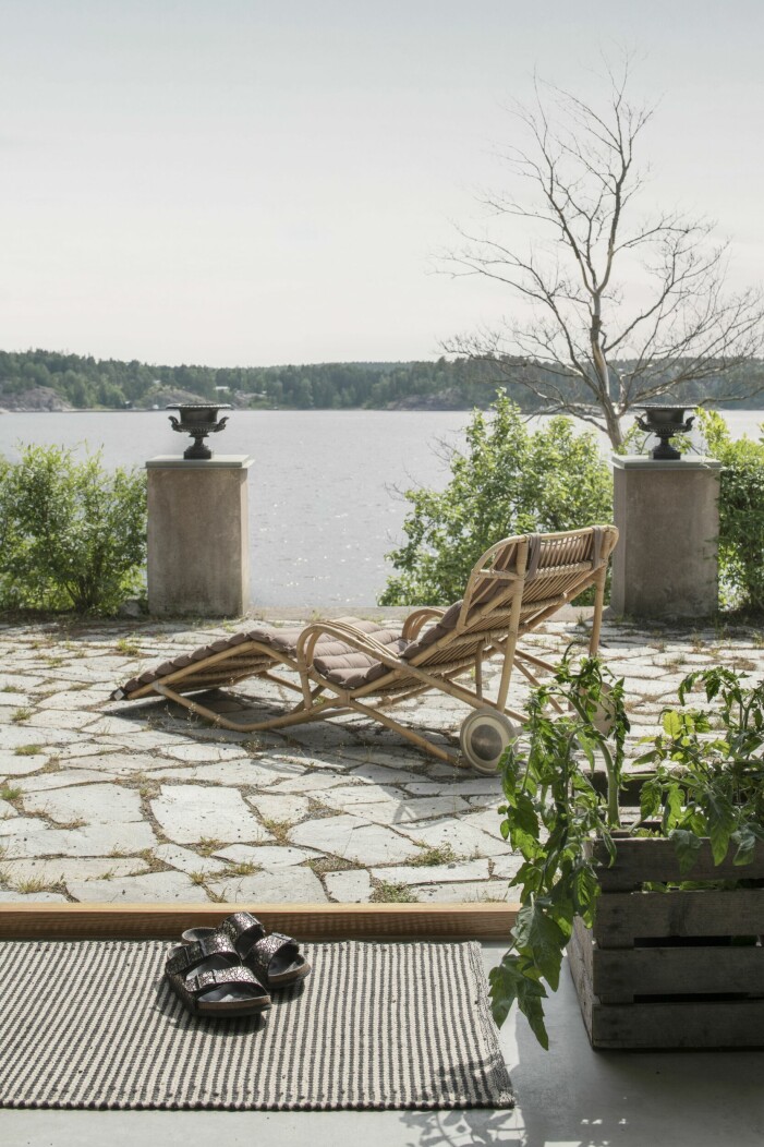 Solstolen i rotting fanns i huset. Terrassen är belagd med ljus skiffer för att matcha husgrunden. Solstol Rotting på uteplats.