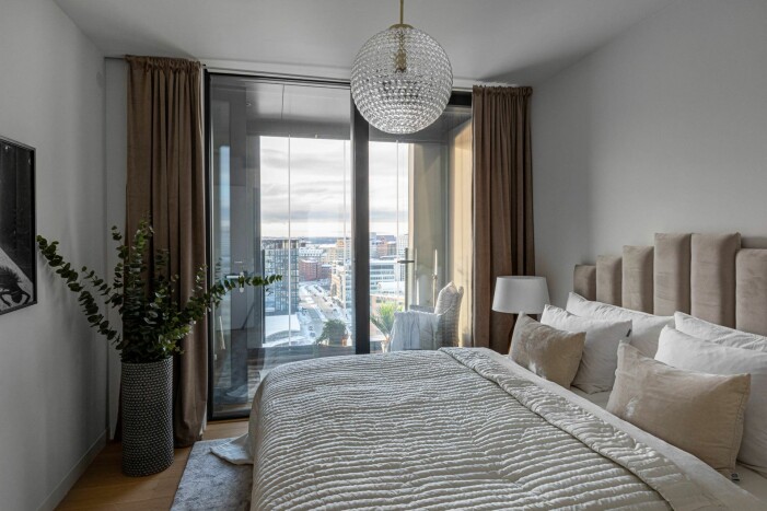 Ett av tre sovrum, detta beläget precis bredvid en av fastighetens två inglasade balkonger. Sovrum med utsikt över centrala Stockholm