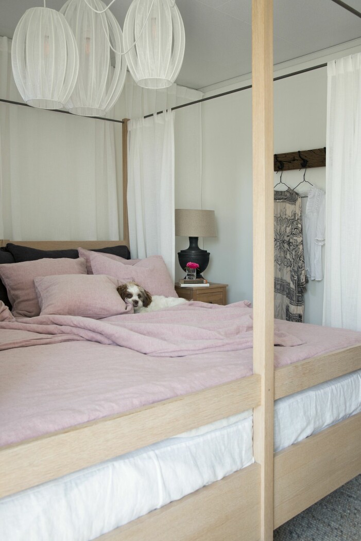 Himmelssängen i vitlaserad ek kommer från ett hotell, Maria hittade den på Blocket. Rosa linnelakan från Himla, sängdraperier från Hemtex och en rosa pläd med stor mysfaktor från Closet & House. Stor säng i ljust sovrum.