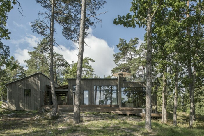 Huset smyger i naturen, nästan som en militär byggnad. Vardagsrummet är sänkt för att ge plats åt en takterrass. Stor sportstuga i skogen.