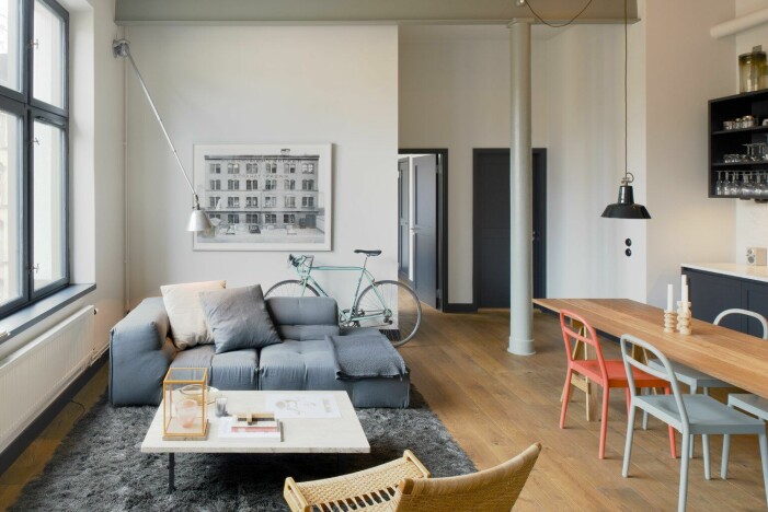 Ljuset strömmar från det väldiga fabriksfönstret och belyser Patricia Urquiolas Tufty-Too-soffa för B&B och matta i specialbeställd grå nyans av Gunilla Lagerhem-Ullberg för KasthallClick to add image caption Arkitekten Andreas Martin-Löf säljer sin lägenhet i stråhattfabriken på Kungsholmen