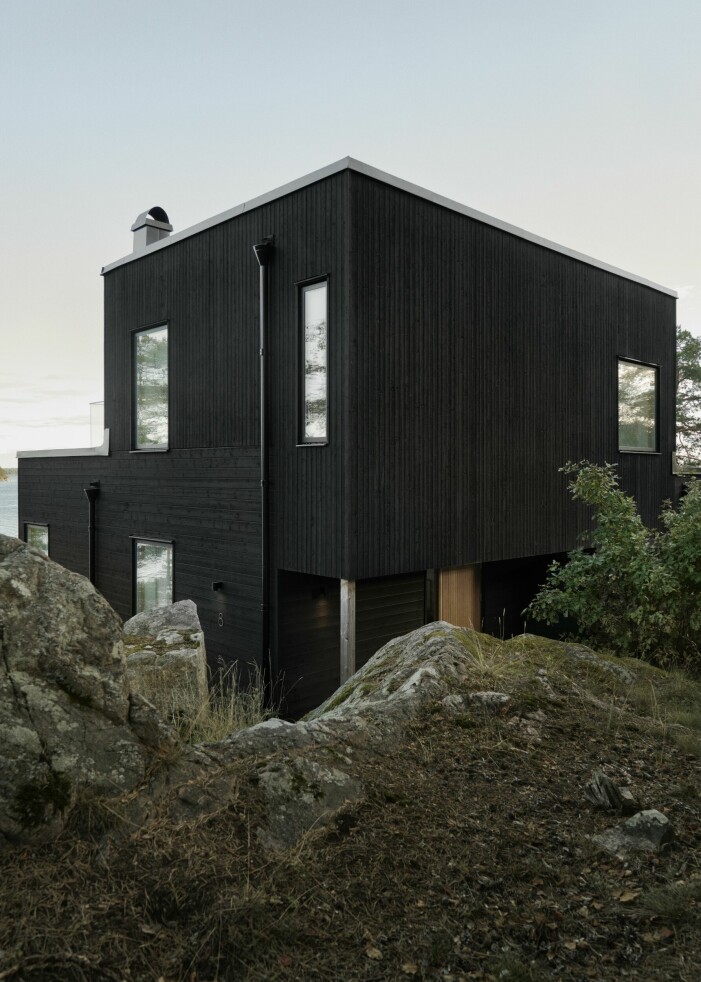 Huset placerades väldigt nära bergväggen. Av hänsyn till naturen ville Anna och hennes man spränga bort så lite berg som möjligt. Svart hus på klippa.
