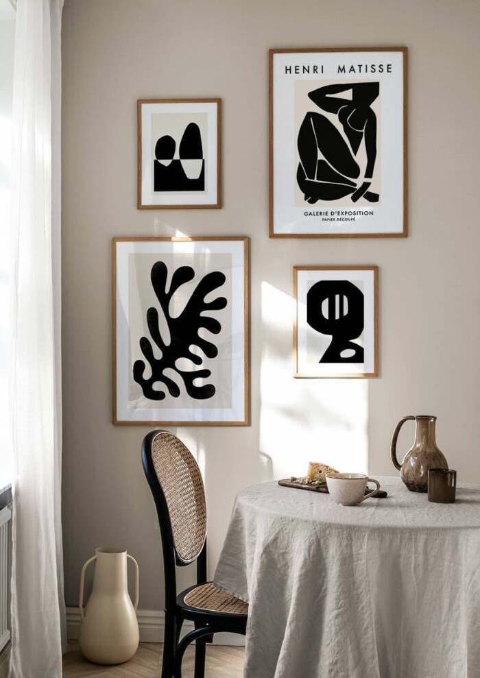 Lyckas med upphängningen av tavelväggen genom att utgå från ögonhöjd. Foto: Postery Stilfull beige, vit och svart tavelvägg från postery