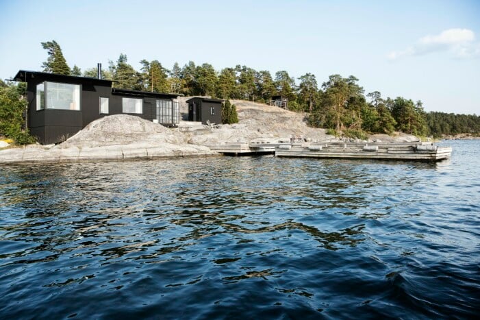 Efter att ha skissat varje sommar, och varje höst bordlagt byggplanerna, blev det till slut ändå så att Thomas byggde ut ett av husen på sommarstället. Strandhuset kilar in sig mellan klipporna, dramatiskt nära havet. På den vackra klippan framför syns märken efter högvatten och is. Utbyggt sommarhus och strandhus mellan klippor.