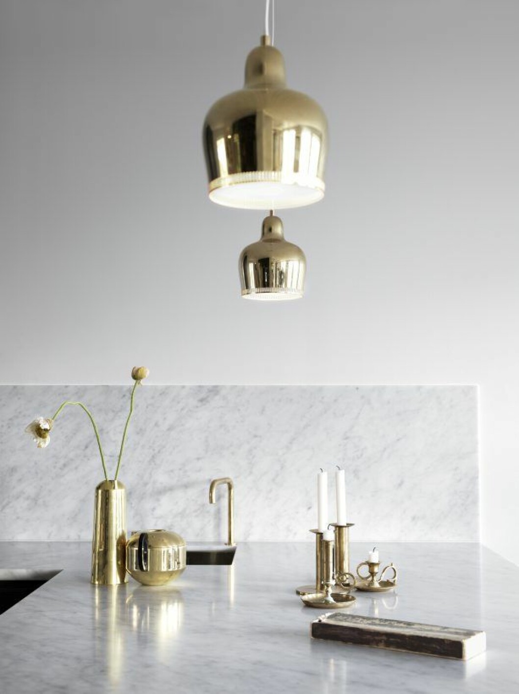Marmor och mässing i skön förening. Bredvid spisen finns en liten extraho för att hälla av pastavattnet och annat. Mässingvaser Eclectic by Tom Dixon, ljusstakar antikt. Tommy_Residence_5