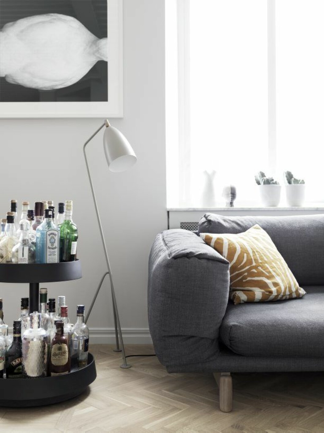 I vardagsrummet med soffa Rest från Muuto, ett egensnickrat soffbord av upphittad dörr, stol Vitra. Takspottar, Jonas Bohlin. Golvlampa nedan Gubi, kudde Hay, drinkvagn L K Hjelle. Tommy_Residence_6