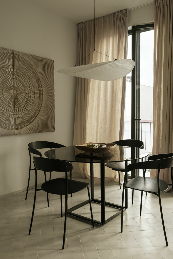 Maria har valt neutrala toner och blandar svart, vitt och beige med trä. Möbler och lampa från New works och tavla av en lokal konstnär. Golvplattorna i cement är gjutna för hand och lagda i fiskbensmönster. Townhouse på Mallorca, matsal