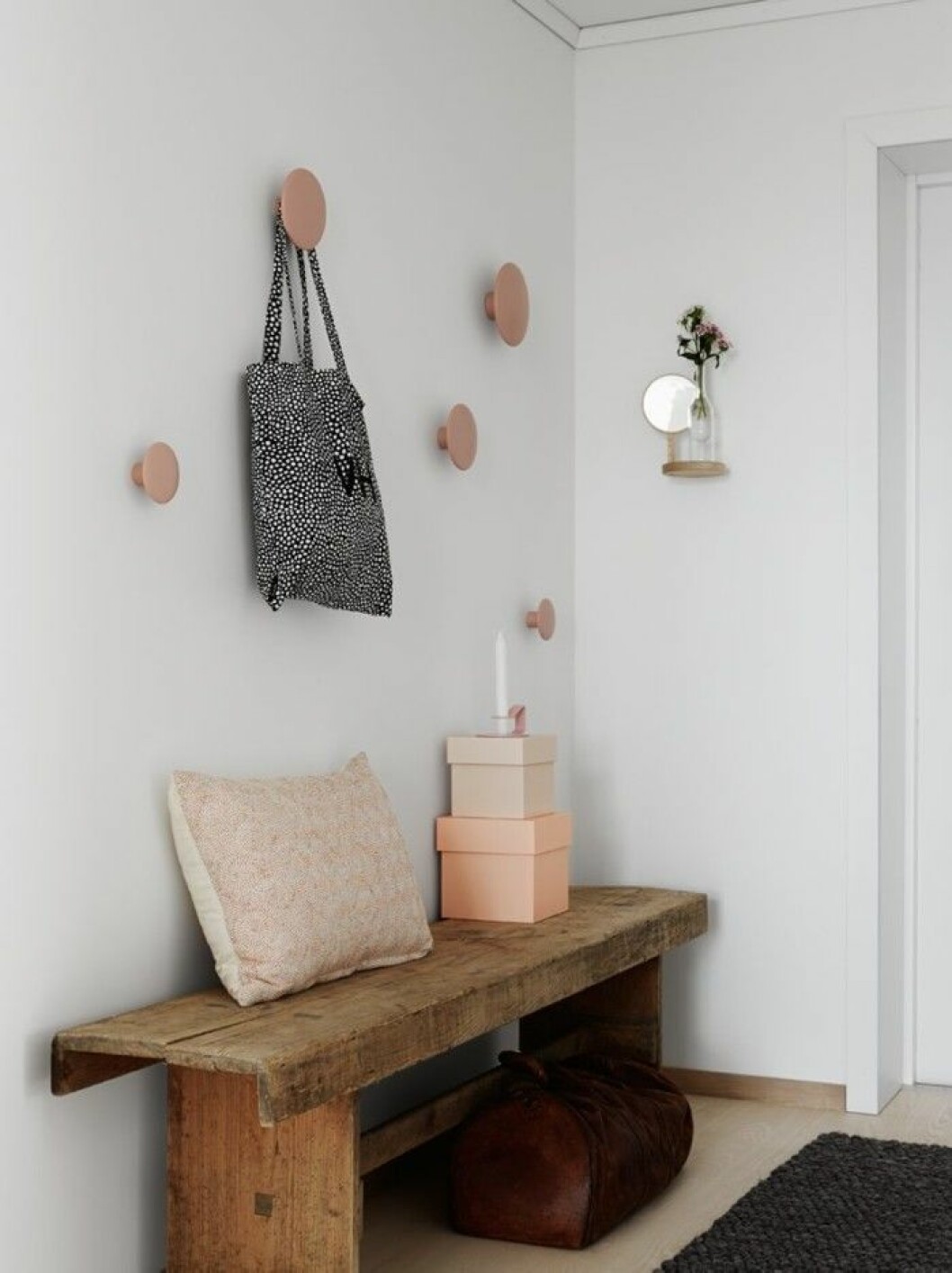 På bänken, lådor från Hay, kudde från Muuto och ljusstake från Normann Copenhagen. Matta, Hay. Krokar Dots från Muuto, tygpåse från Wrong for Hay. Liten spegel från Moustache, Lotta Agaton shop. Inget vanligt ekande trapphus. Husets foajé har träväggar och kalkstensgolv. Bänk byggd av Folkhem. Trasmak_10_2-700x935