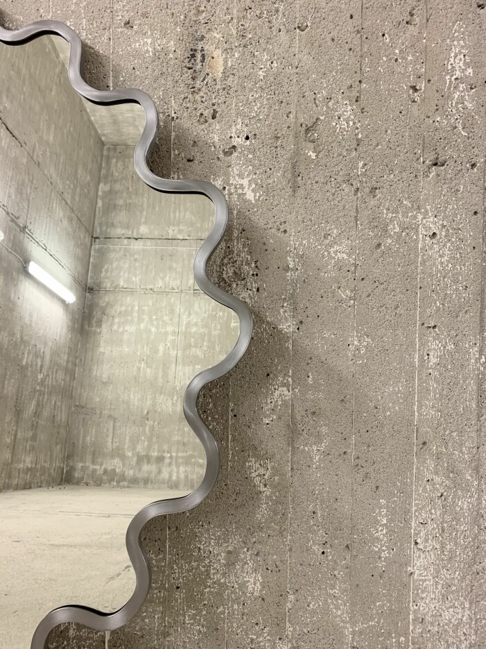 Udisons material är svartstål och glas och en träskiva som baksida. Metallplatta som man skruvar upp på väggen som man hakar på spegeln (en hane och en hona på spegeln). Spegeln är även skyddad med en halvmatt lack för att undvika rost. En bordspegel kommer under sommaren. Sigge Billgrens spegel Udiso
