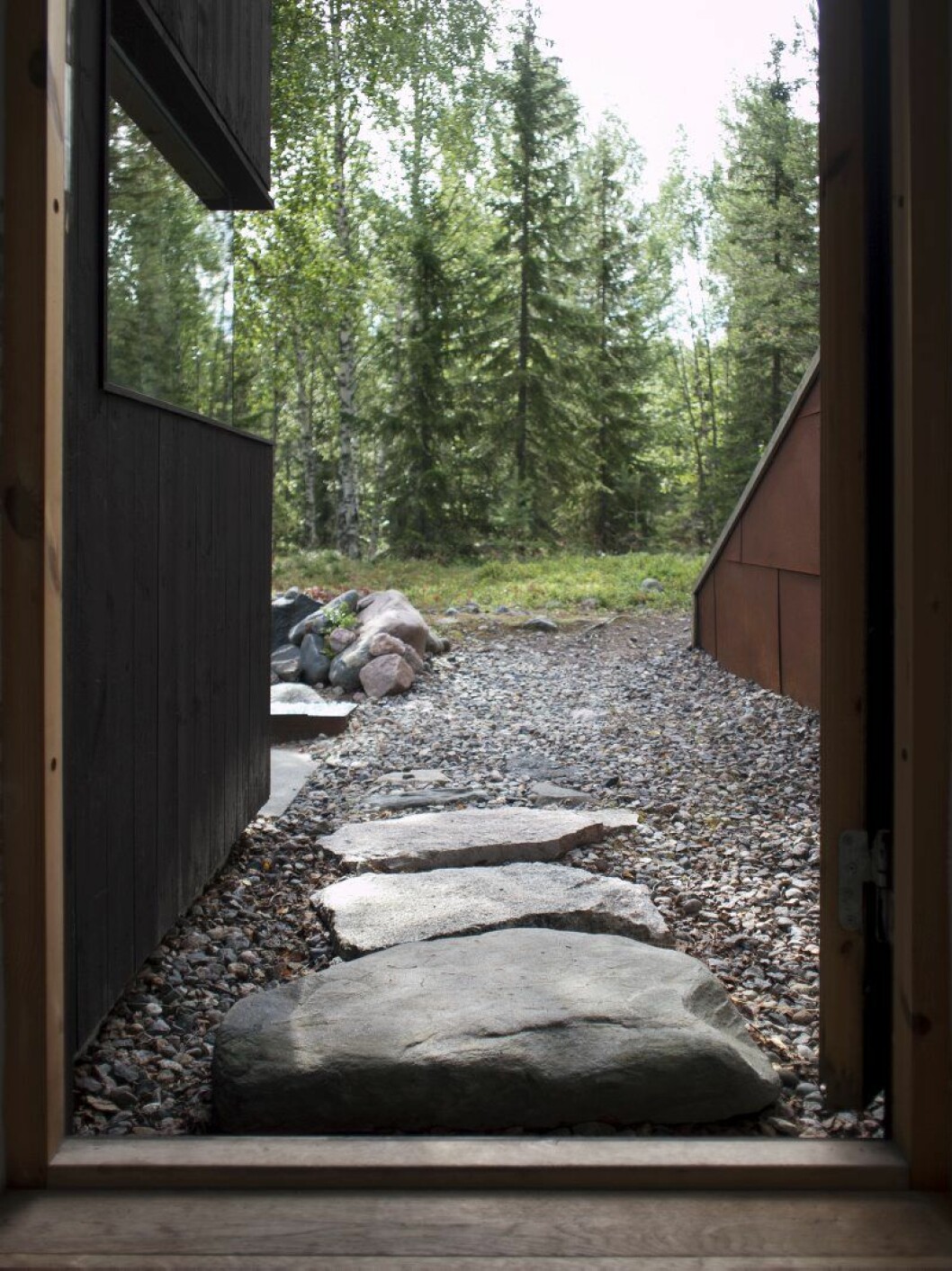 Ett sommarliv nära barndomsskogen. Bakom muren av corténstål finns en skyddad innergård. Ett sommarliv nära barndomsskogen. Bakom muren av corténstål finns en skyddad innergård.
