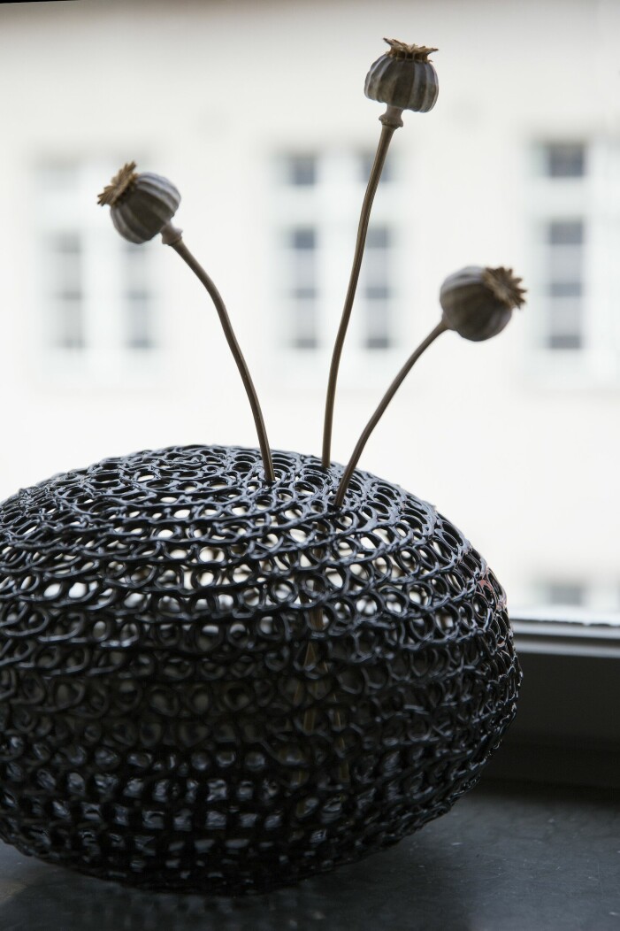 Nätvasen med vallmokapslar är en lampskärm inhandlad på second hand. När den vändes uppochner blev den en perfekt hållare för torkade blommor. Våningen med det lilla extra – hemma hos inredaren Nellie Fasth