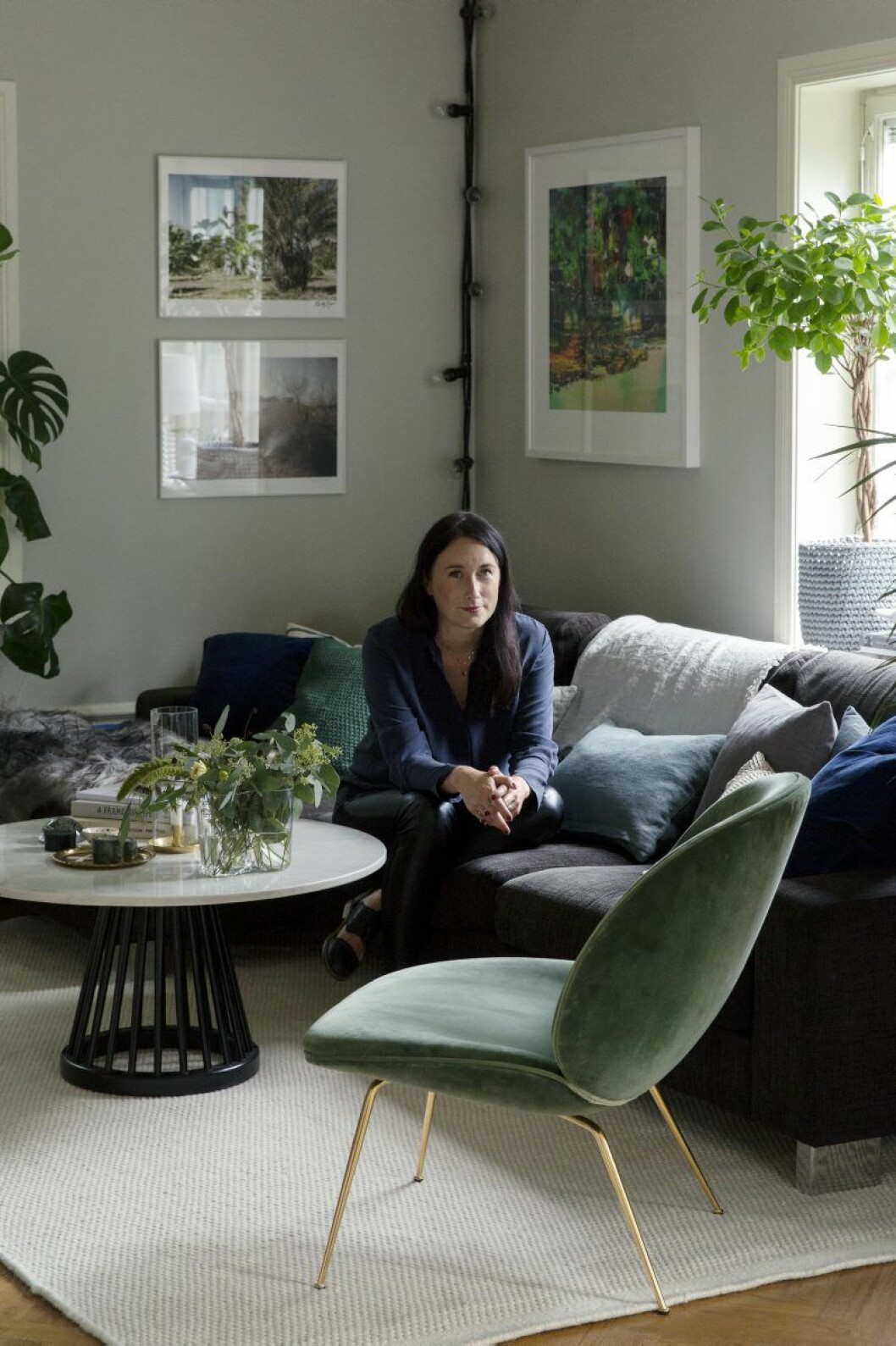Anna Mårselius har valt att snygga till den superfunktionella familjesoffan med kuddar i blått och grönt. Även tavlorna går i samma färgskala och hittades på loppis i LA samt på Konstbar. Vardagsrum 9_2015_14