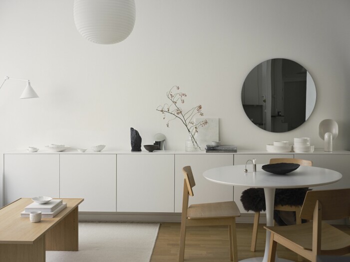 Den långa förvaringsbänken är dimensionerad för att kunna rymma köksgeråd. Vägglampan är köpt på Ellos och lackerad vit. Under lampan och på soffbordet står Simons egen keramik. Matbord Docksta, Ikea. Stolar, Ikea. Vardagsrum hemma hos Simon Strömstedt