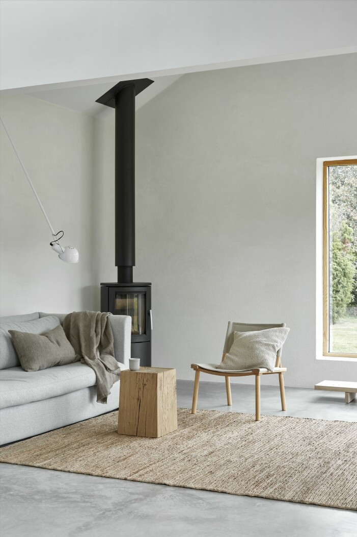 Vardagsrummet är sparsamt möblerat med noggrant utvalda möbler. Stol från Nikari. Soffa Hackney, Hay. Vägglampa 265, Flos. Braskaminen är dansk och heter Aura 1. Vardagsrum ljust och enkelt inrett.