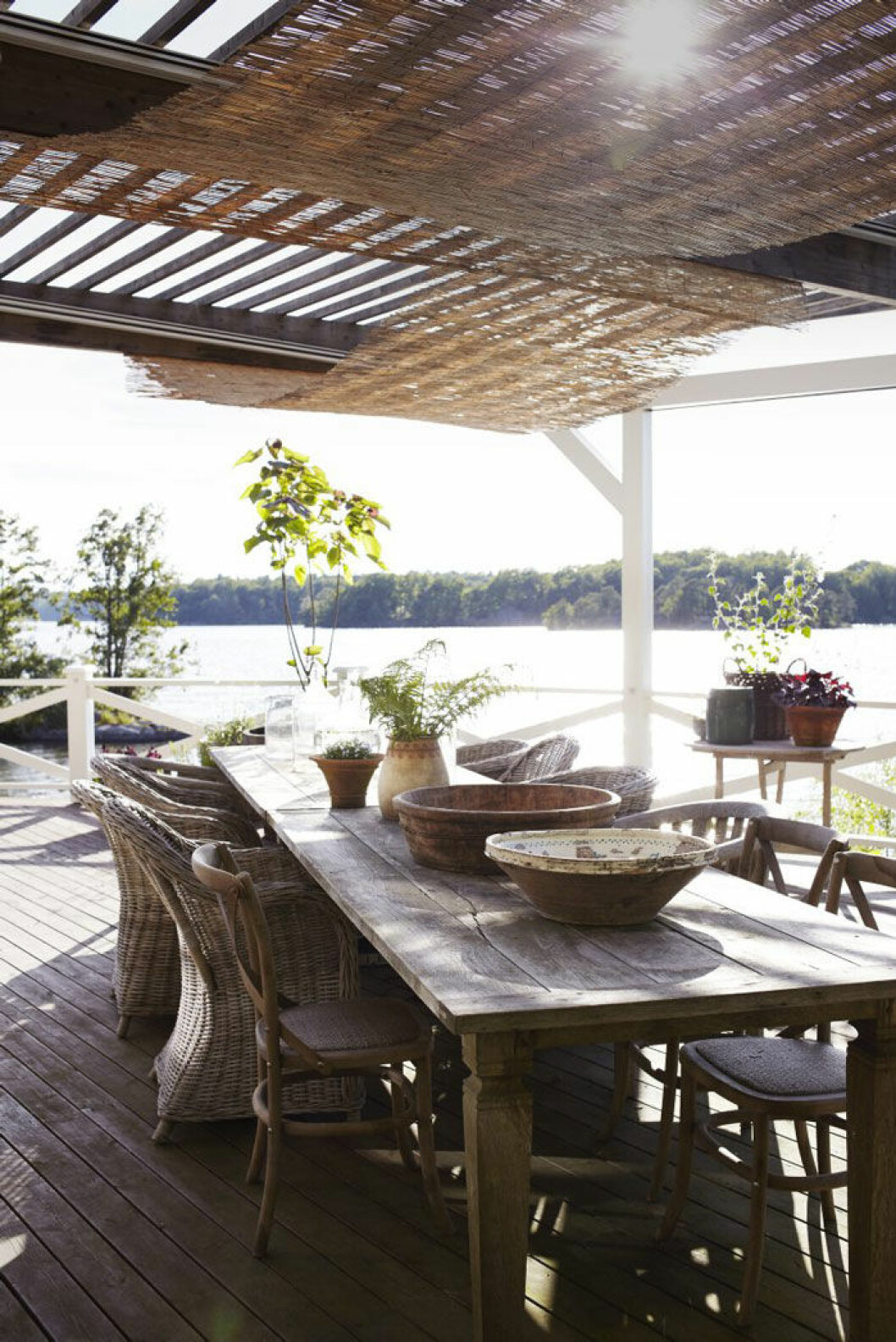På den stora terrassen som ligger i söderläge har Johan och Victoria ställt två rejäla bord för alla gästabud. I taket hänger vassmattor som skuggar mot solen. I ekfaten<br>i bakgrunden växer fliksumak och tulpanträd. Hemma hos Victoria Skoglund