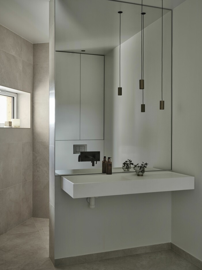 Handfatet i Corian samt klinkergolvet kommer från Casa dolce casa. Bakom spegeln ligger duschutrymmet, även det med utsikt mot havet. Badrum i modern och minimalistisk tappning.