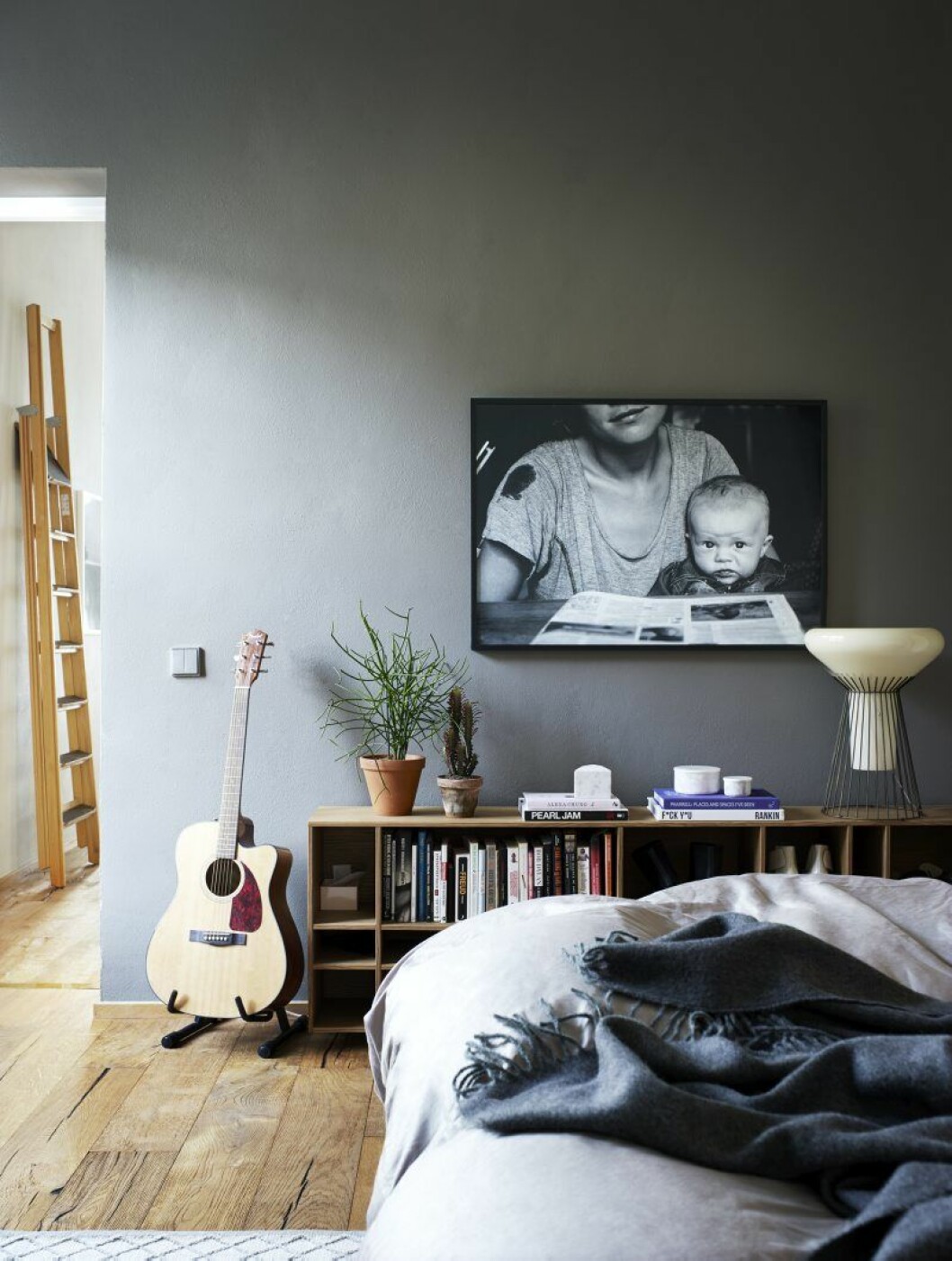 I sovrummet blev det en mörkare nyans på väggen. Porträttfoto av barnmamman Sally Voltaire och sonen Marc. På byrån Kilt Open från Asplund står bordslampan Metafisica från Diesel/Foscarini. Walter Naeslunds hem2