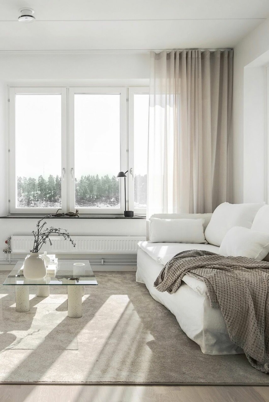 Soffa från Ikea med klädsel från Bemz, soffbord är en DIY (vaser och glasskiva från Bolia), lampa i fönstret från Menu, gardiner från Addetails.