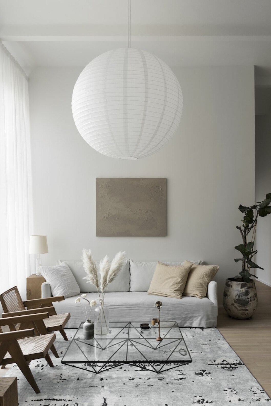 <em>Om du googlar på världens största rislampa får du träff på den här: tre meter i diameter och hitlevererad från Danmark. Soffa och kruka Perspective studio, glasbord Paolo Piva B&B Italia, matta Artilleriet, träpiedestal inredning från Carin Wester shop, lampa (på piedestal)Martin Margiela, ljusstake Perspective studio, vas Granit, tavla Annaleena Leino Karlsson, rislampa Pachia.</em>