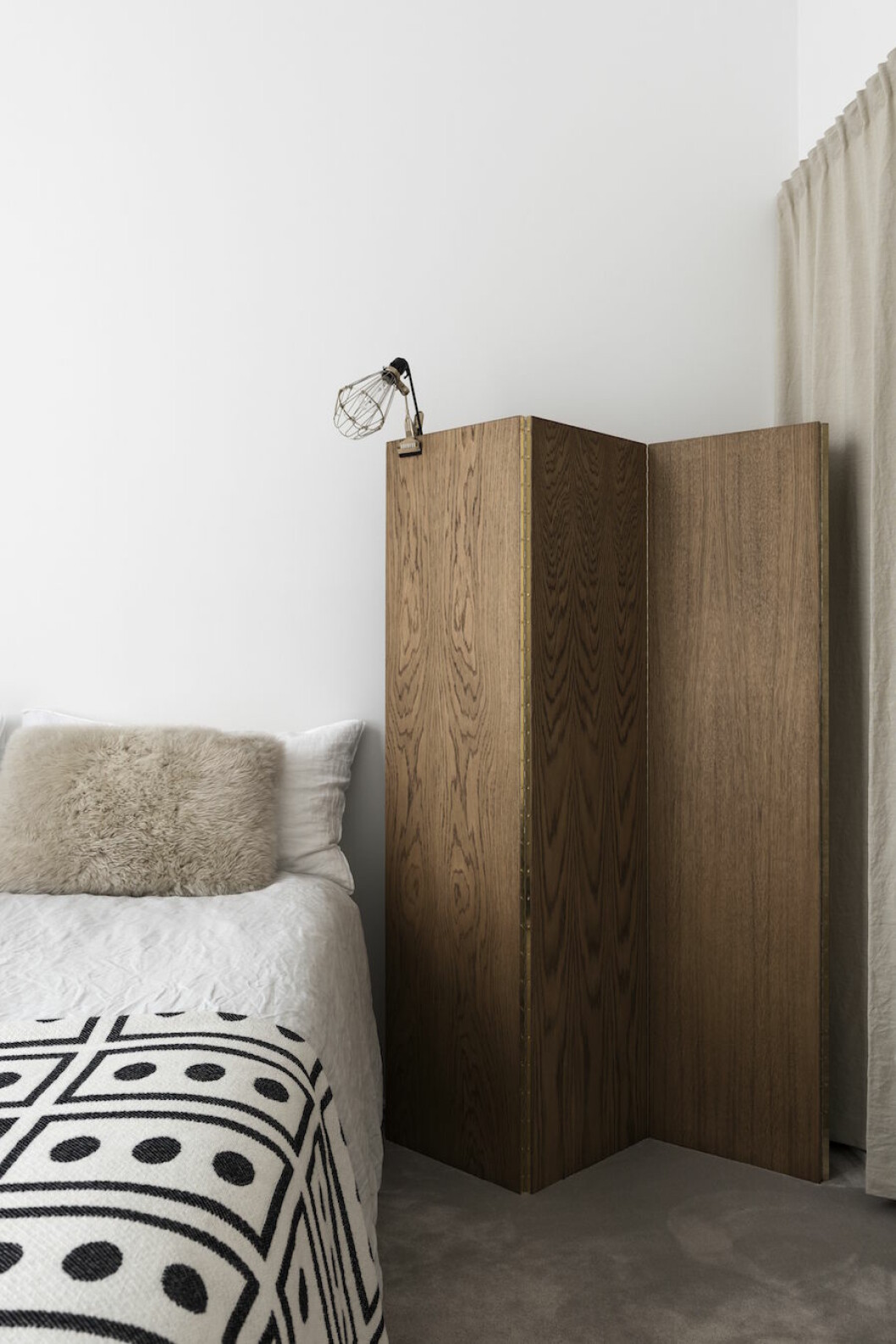 <em>Till vänster: Lampa Hay, vikvägg Snickar- glädje, kudde Linum, överkast från NK inredning.</em>