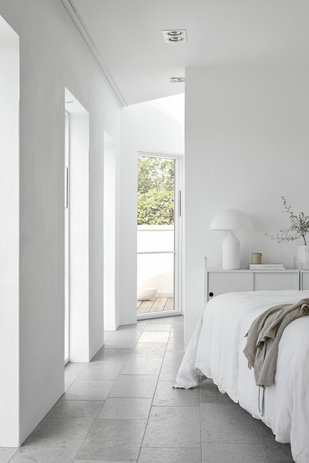 På anda sidan sovrummet finns ett litet kontor med takfönster. Hylla, String furniture. Bordslampa Atollo, design Vico Magistretti för italienska Oluce. Hylla, String furniture. Bordslampa Atollo, design Vico Magistretti för italienska Oluce.