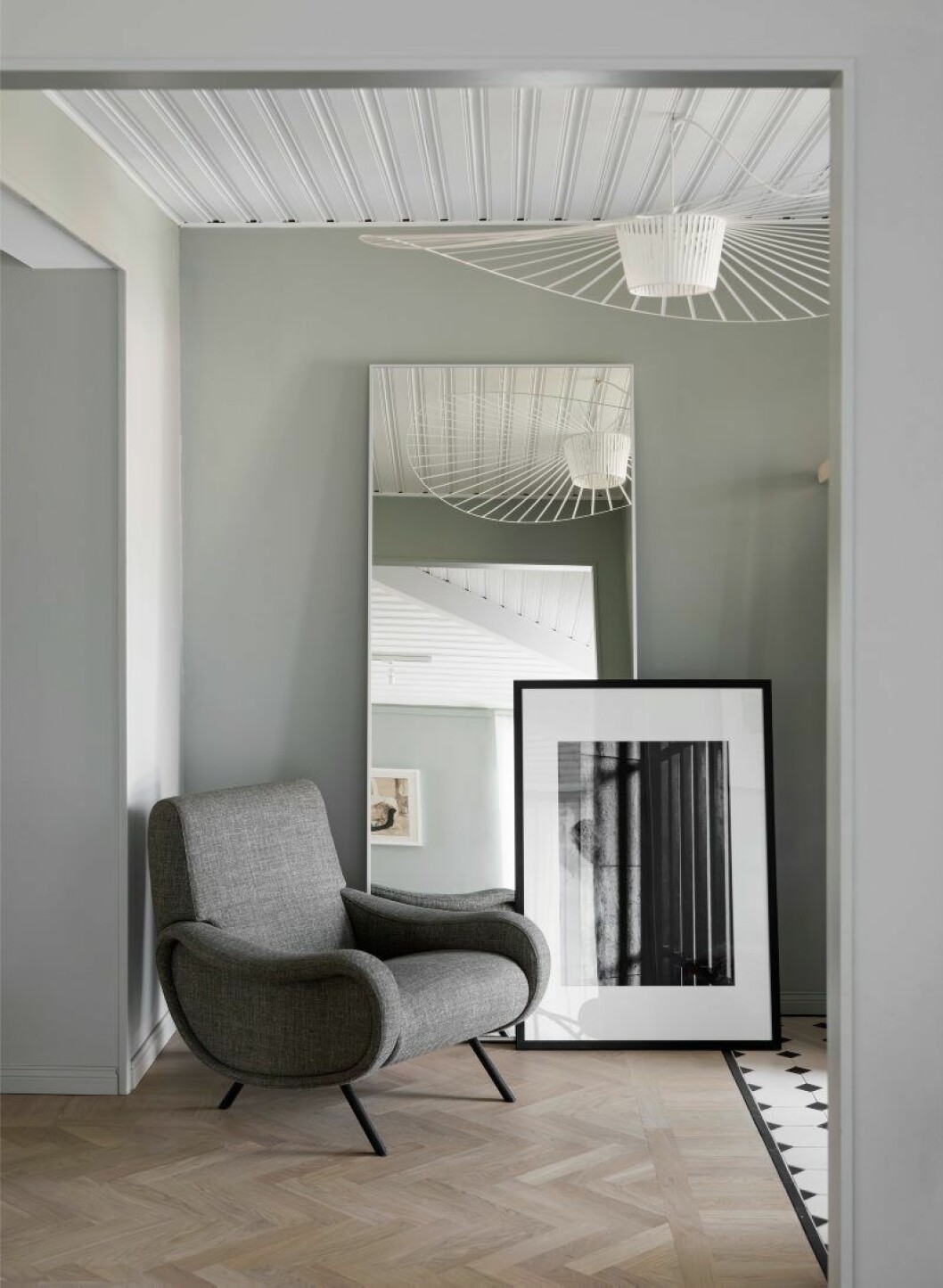 Klinkergolvet i hallen är inspirerat av en inredningsdetalj i tv-serien Downton abbey. Taklampa Vertigo från Petite friture, spegel Ikea, foto av Nicoles bror. Fåtölj Lady av Marco Zanuso för Cassina.